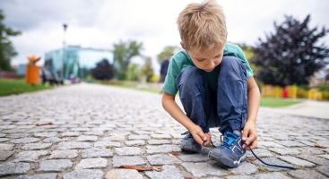 Young boy tying shoe laces
